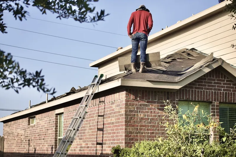 Professional roofer working on a residential roof in Hemlock District